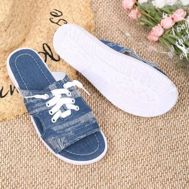 Blue Roman-style women's flat canvas slippers with cloth upper and rubber sole.