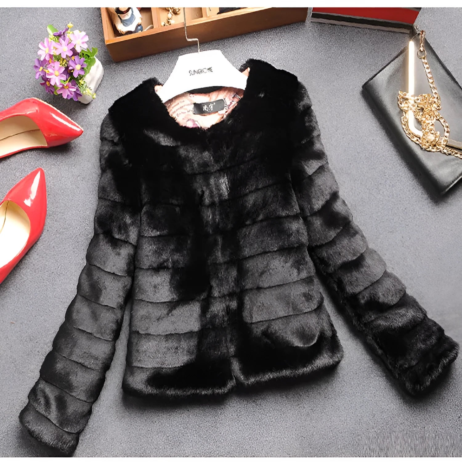 Women's short-length faux fur top in beige on a hanger, showing plush texture and regular sleeves.