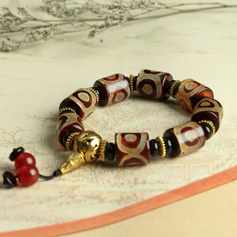Distressed agate Tibet bead bracelet with three-eye motifs and multiple traditional bead styles on wrist