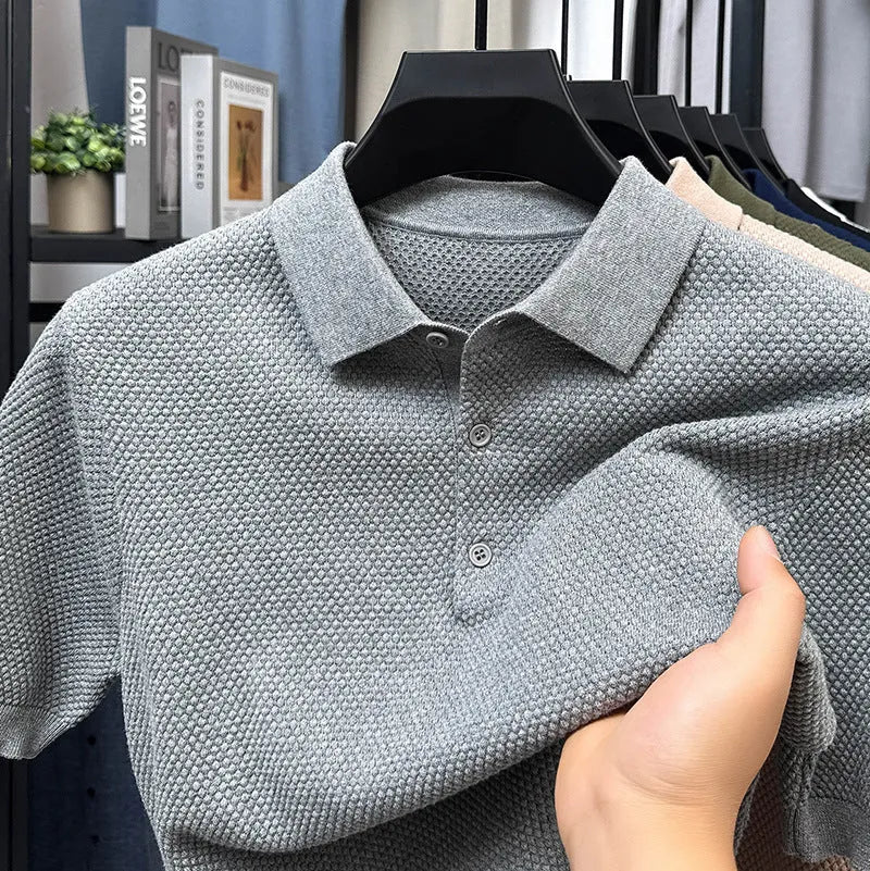 Man wearing a loose-fit grey short sleeve cotton pullover sweater for casual leisure wear.