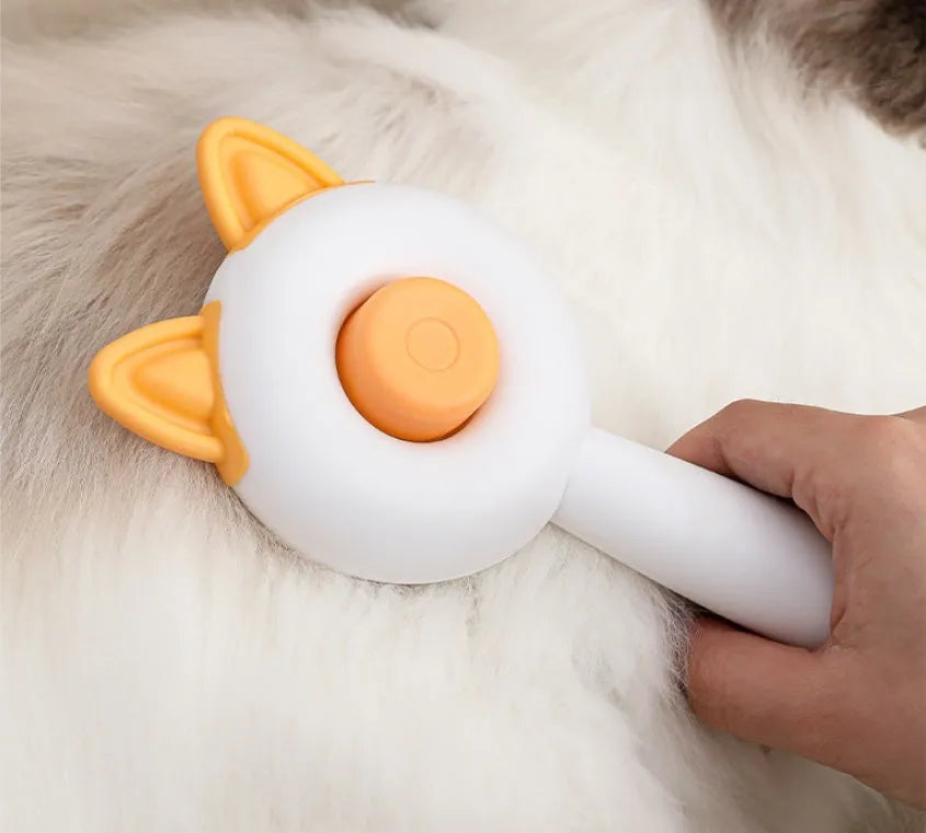 Circular greenish white pet grooming brush with stainless steel teeth and rubber massage nodules.
