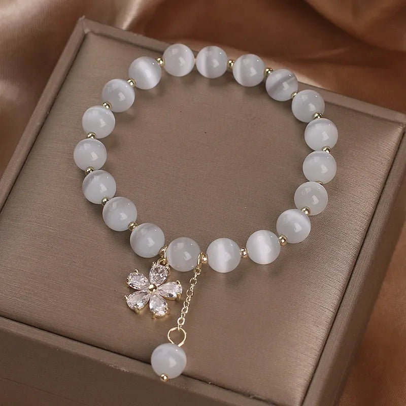 White cat's eye stone women's bracelet with safety buckle pendant and flower tassel detailing