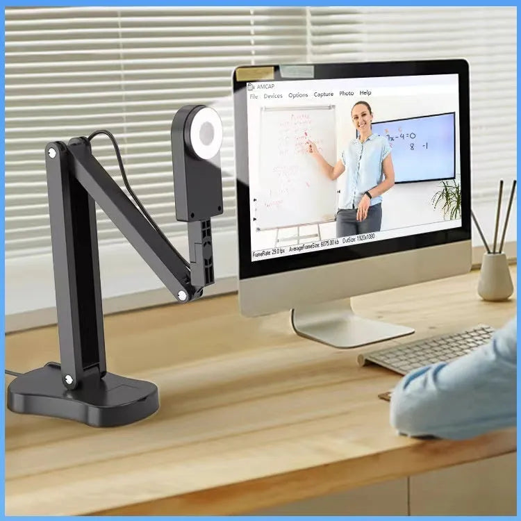 USB computer webcam with microphone for video calls and streaming on a desk.