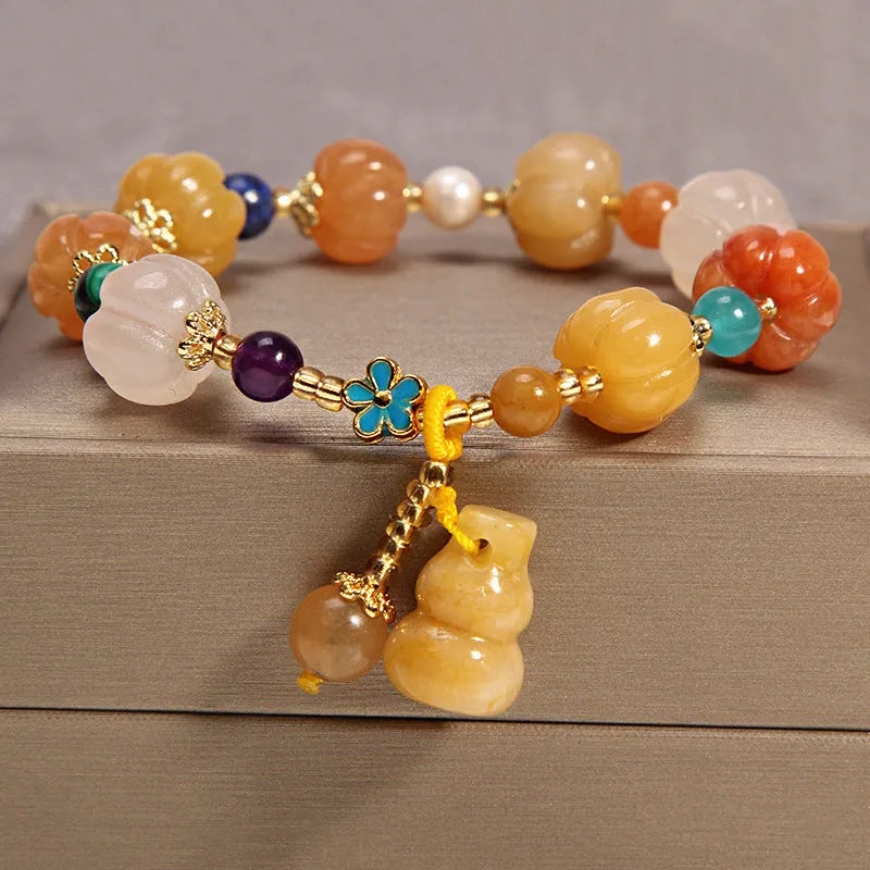 Khaki coloured crystal beads on a gold silk string bracelet, showing adjustable closure.