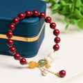Women's natural cinnabar bracelet with a detailed rabbit pendant, shown in red.