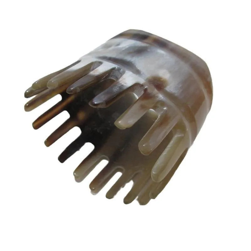 A black horn comb with wide teeth on one side and a pointed tip for scalp massage.