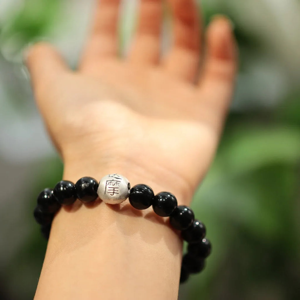 Close-up of a women's bracelet with a 10mm black agate stone and Chinese-style sterling silver and alloy design.