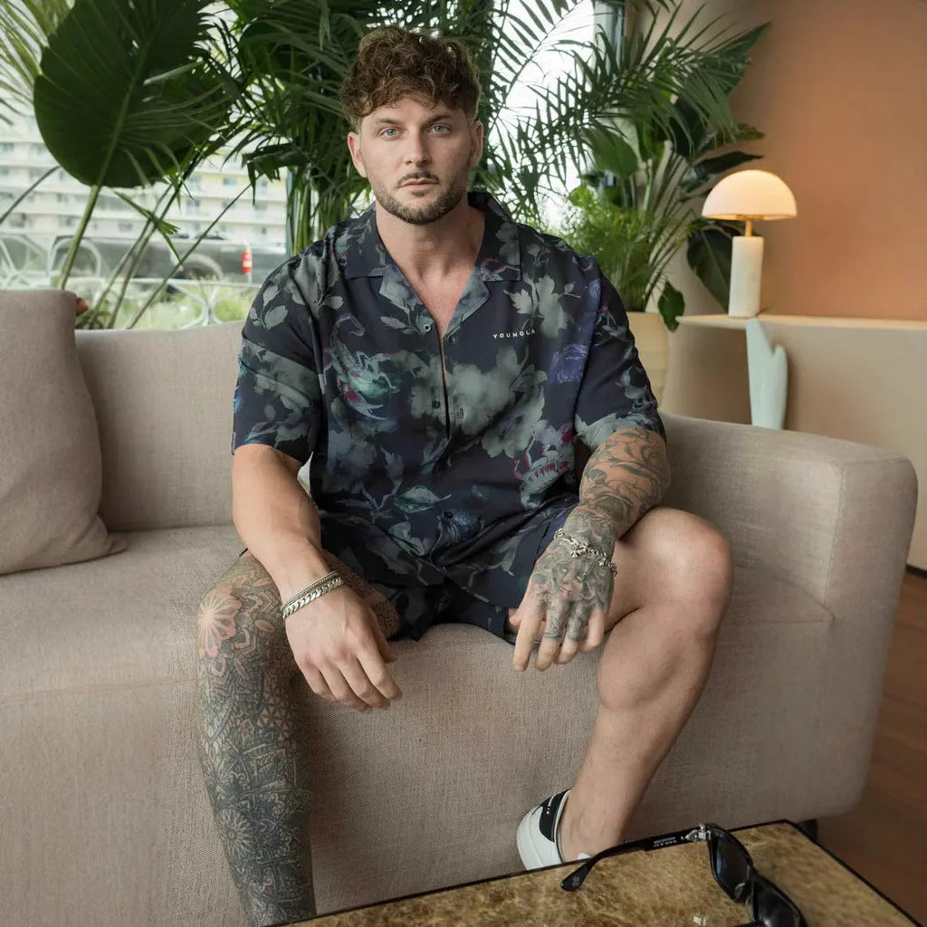 A man's loose grey short-sleeved cardigan with a floral print, showing the elastic band fabric.