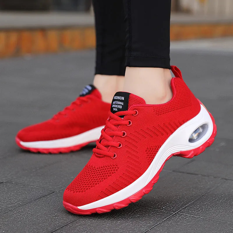 Women's red mesh sneakers with round toe and front lace-up design on flat surface