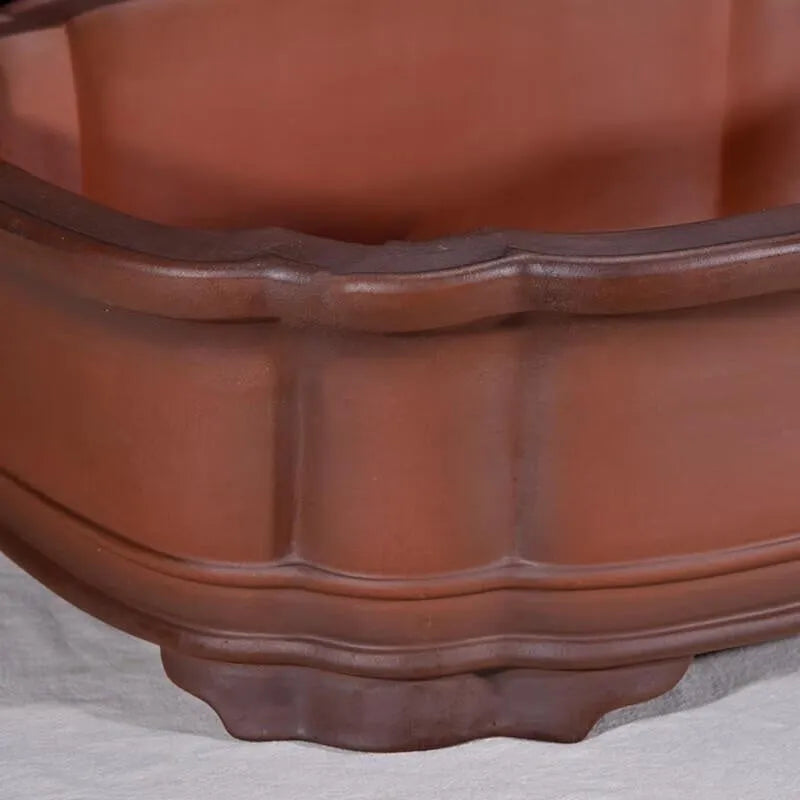 Large antique-finish purple clay flowerpot with raised tree stump and floral design.