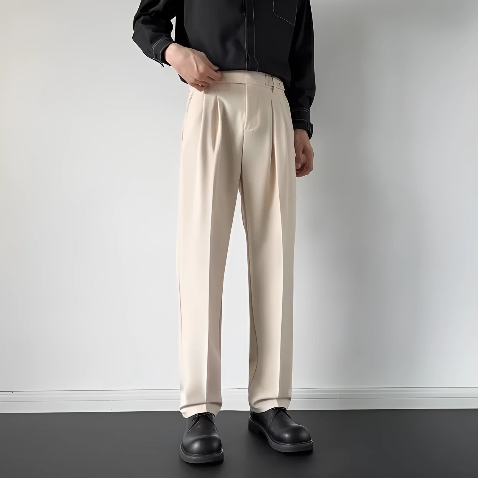 Men's straight loose fit suit trousers in apricot colour, laid flat.