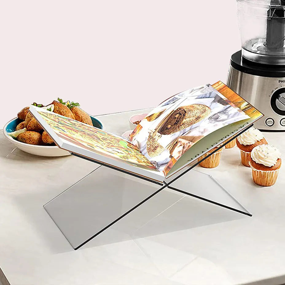 Clear acrylic X-shaped book reading rack holding books and magazines on a desktop