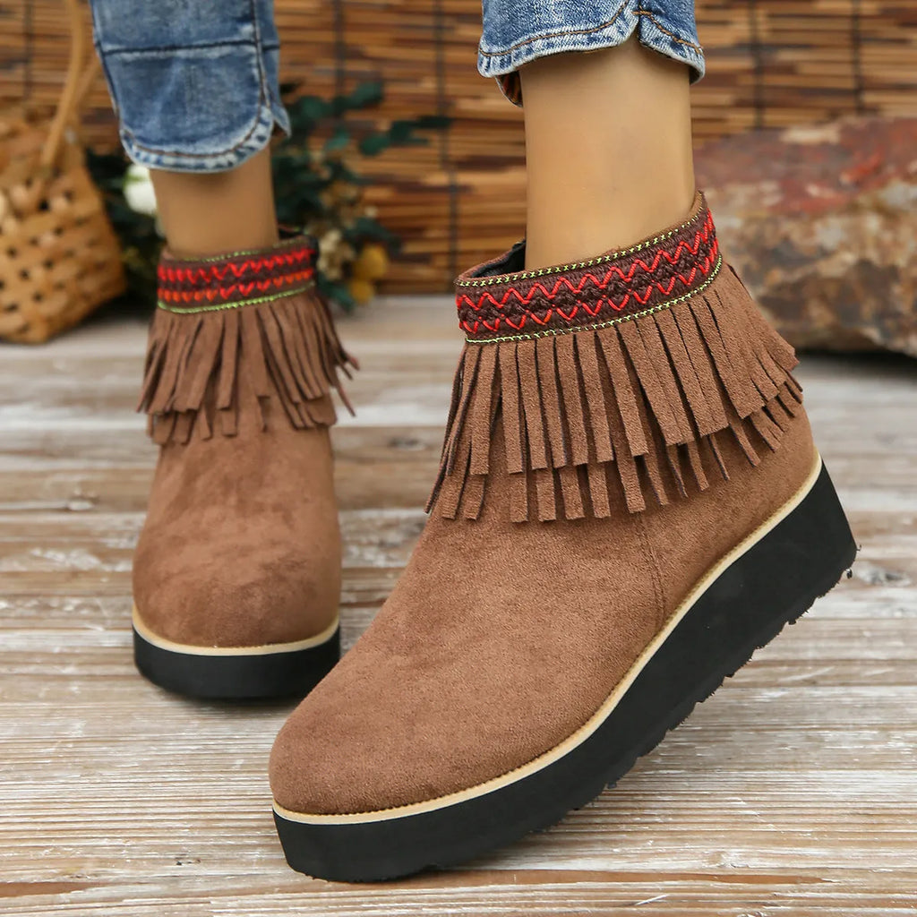 Women's black suede wedge ankle boots with a side zip and tassel detail on a thick rubber sole.