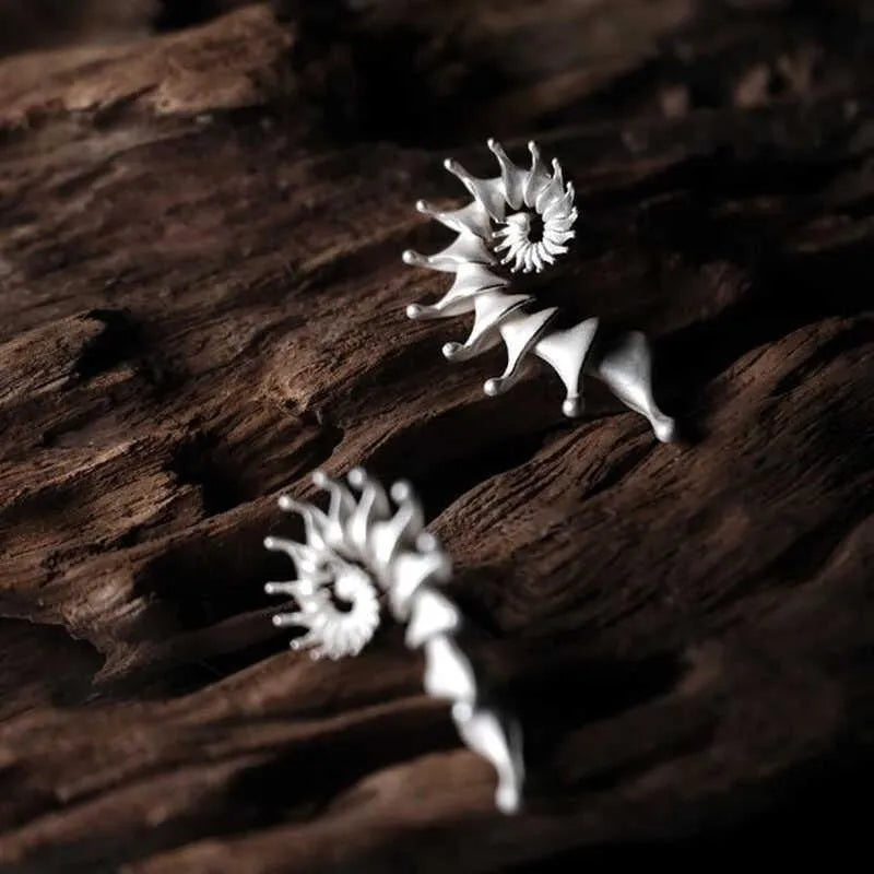 A pair of three-dimensional matte finish conch shell stud earrings in alloy with irregular shaping.