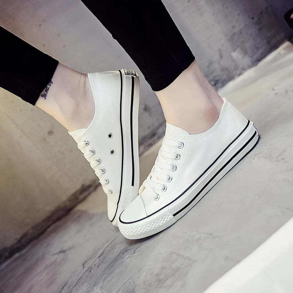 Women's solid colour canvas casual flat shoes on a plain background.