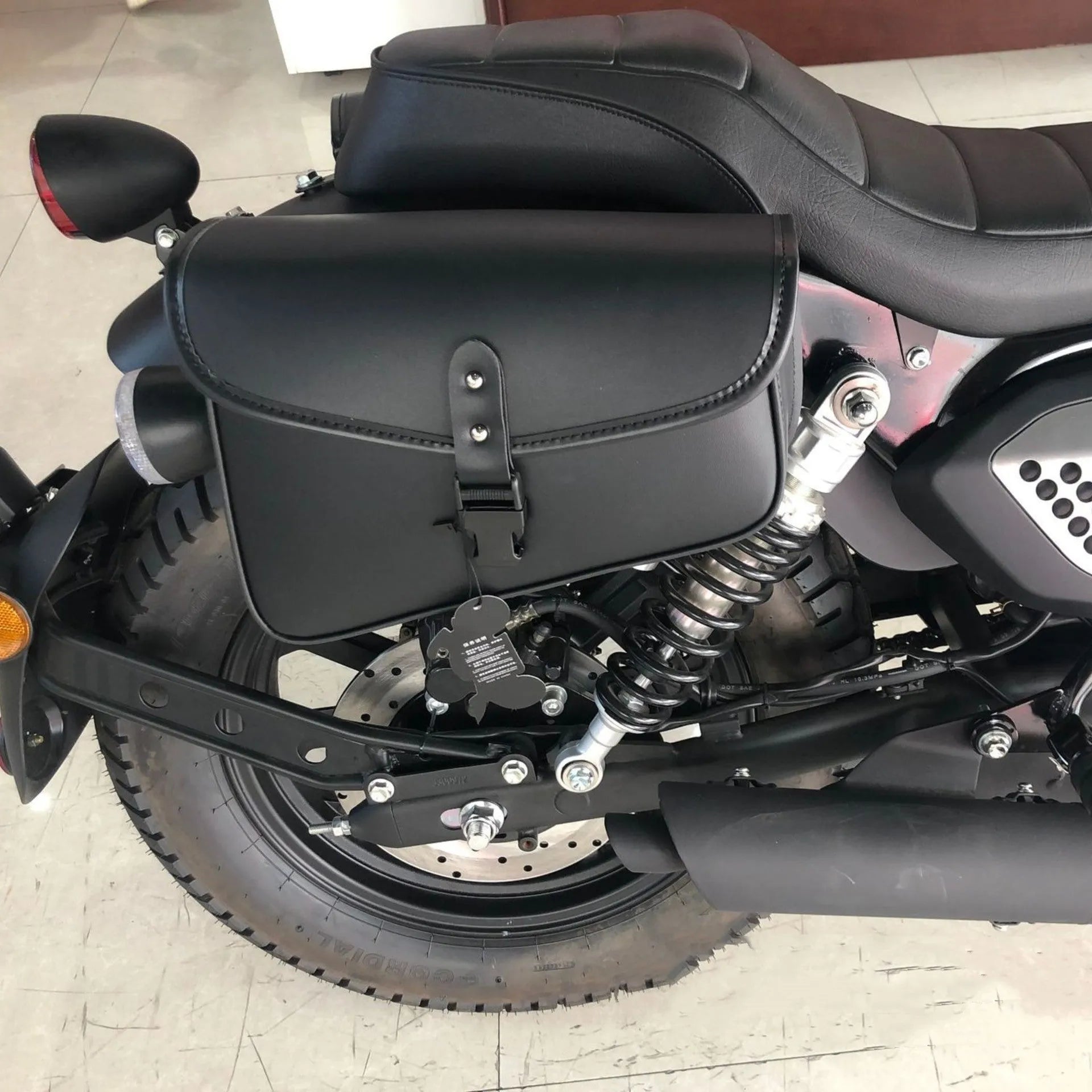 Black PU leather motorcycle swingarm saddlebag mounted on a Harley Sportster side.