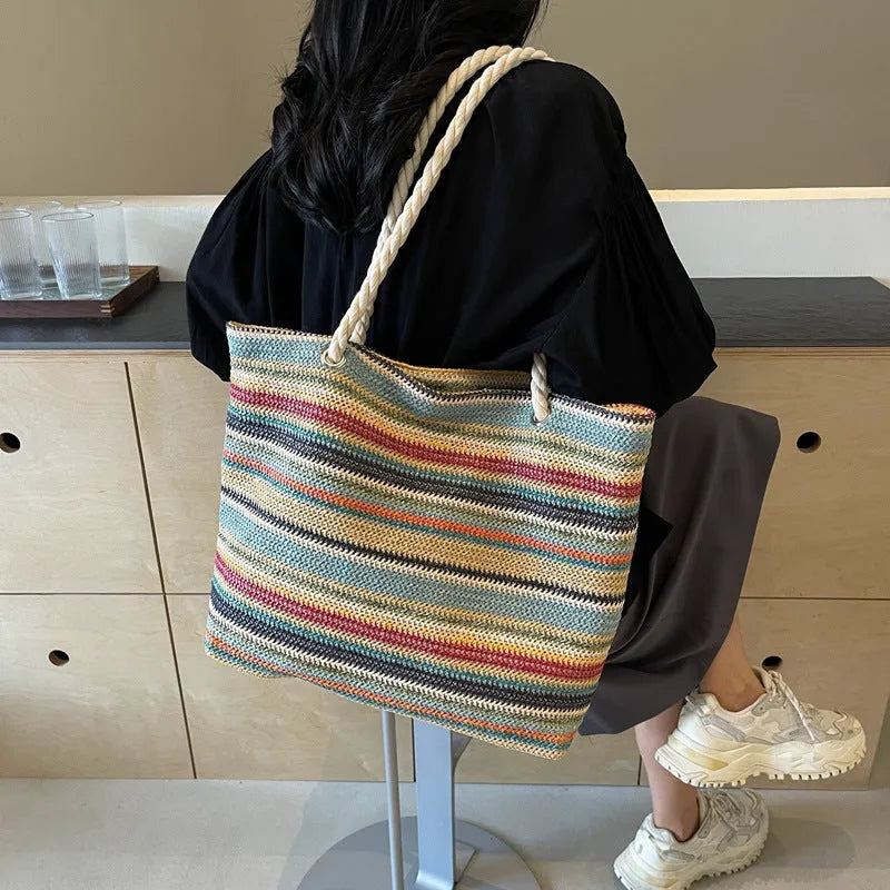 Blue straw woven nylon shoulder bag with large capacity and polyester lining.