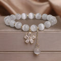 White cat's eye stone women's bracelet with safety buckle pendant and flower tassel detailing