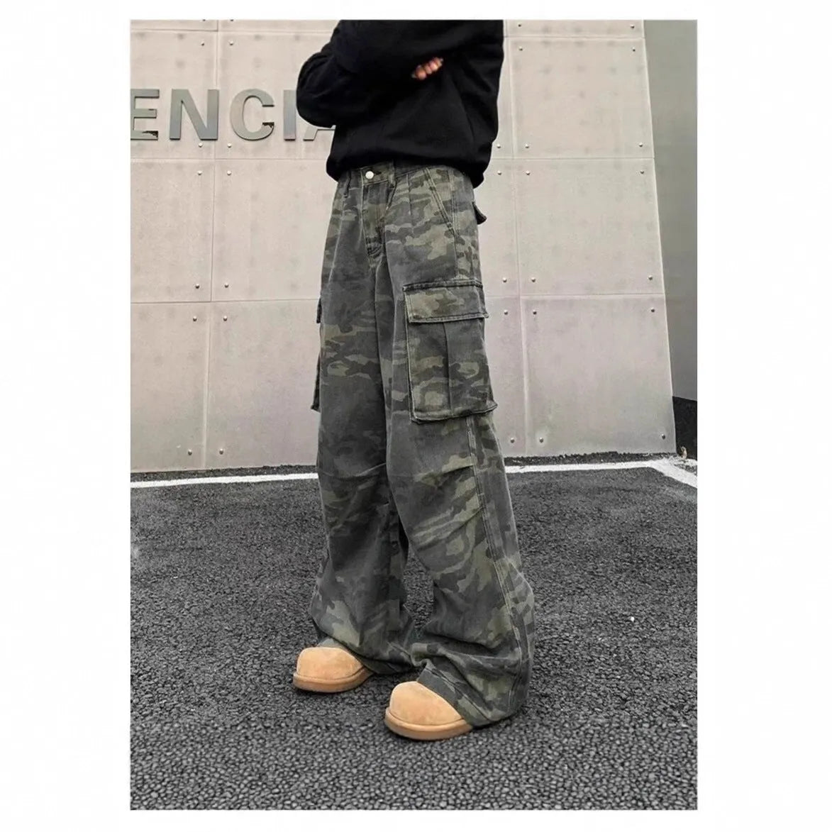 A pair of washed camouflage cotton blend cargo trousers with multiple pockets on a mannequin.