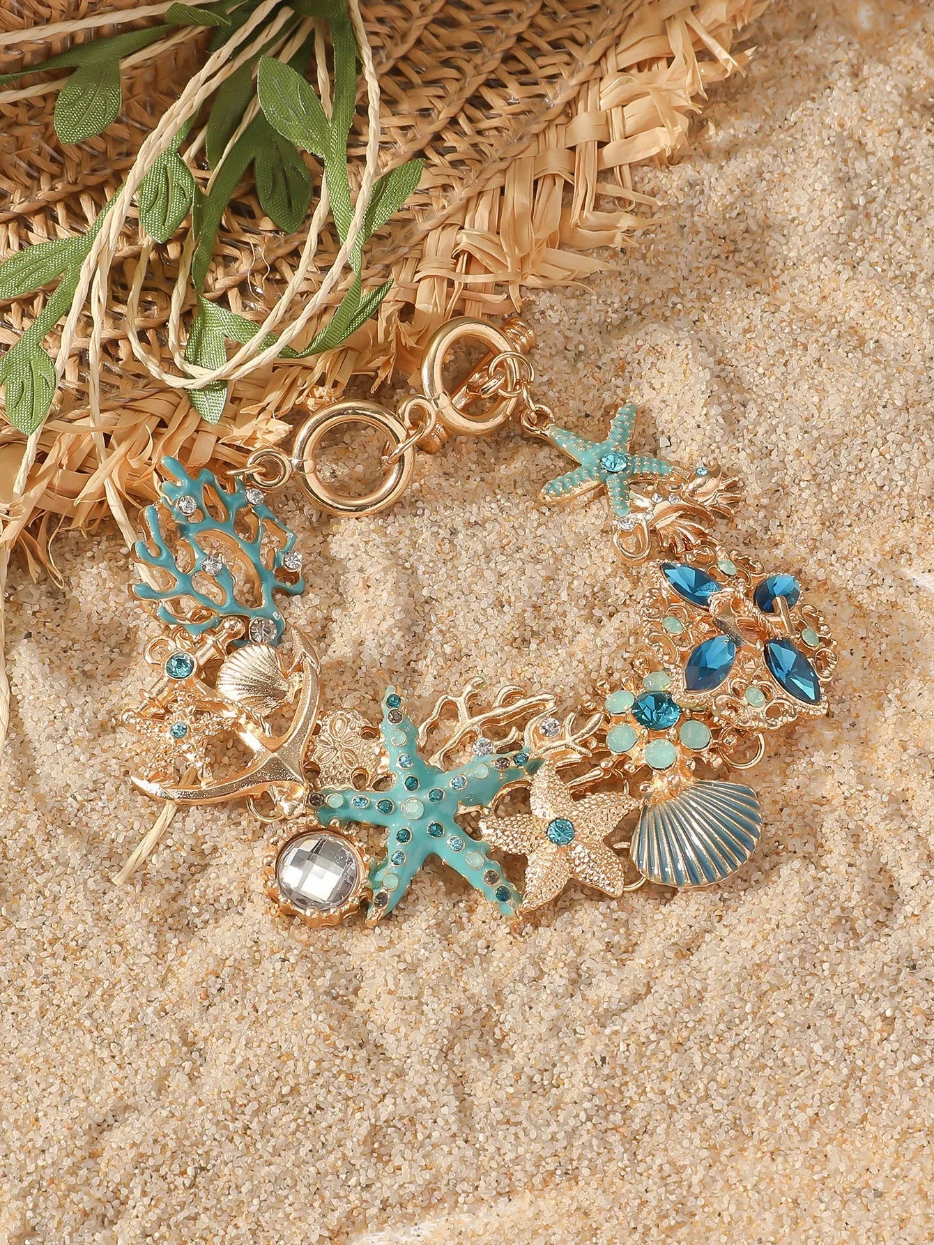 Starfish-shaped alloy bracelet with rhinestone anchor and shell details in turquoise, red, or blue.