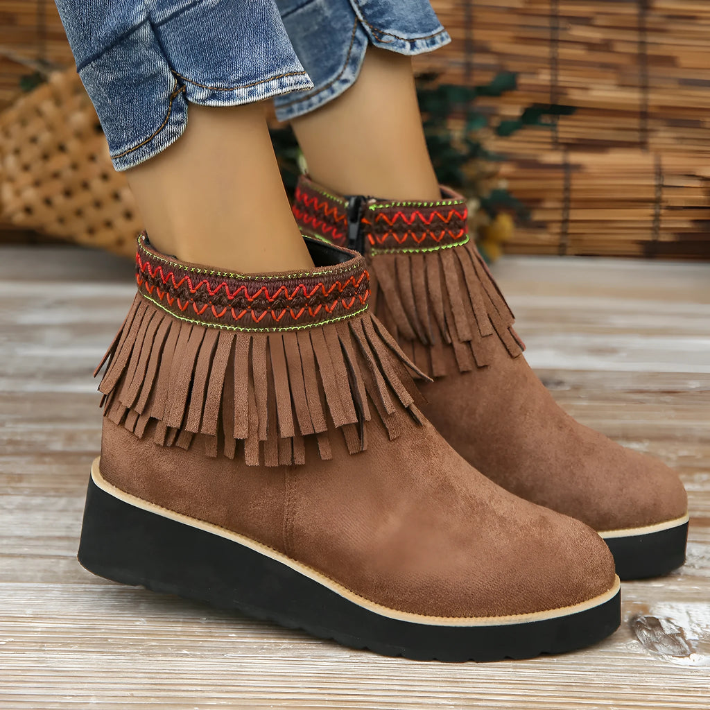 Women's black suede wedge ankle boots with a side zip and tassel detail on a thick rubber sole.