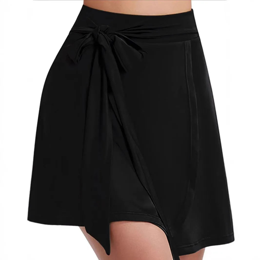 Black thigh-length sports skirt with attached shorts, showing high waist and shoulder strap details.