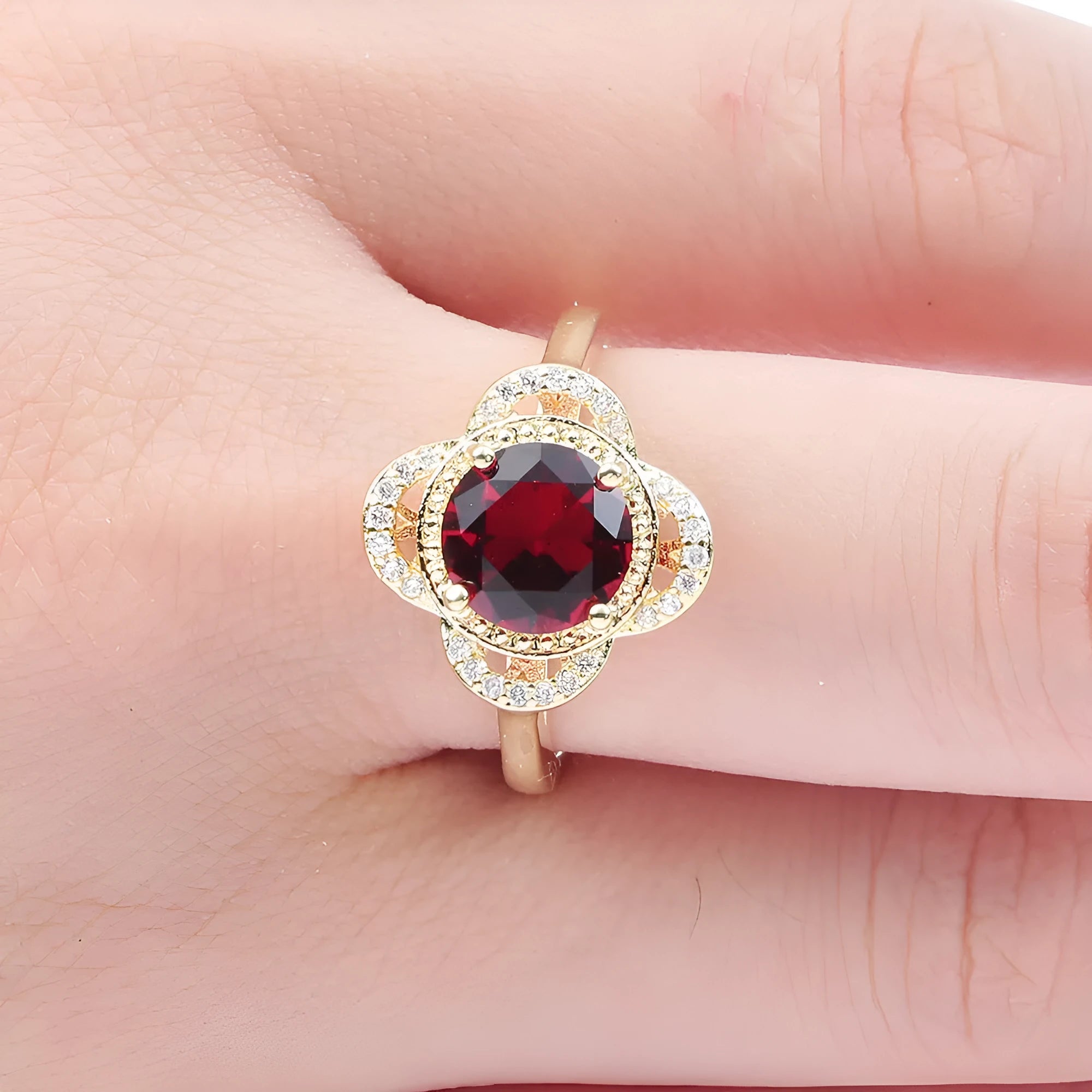 Copper fruit-shaped ring with a zircon stone inlay on a hand.