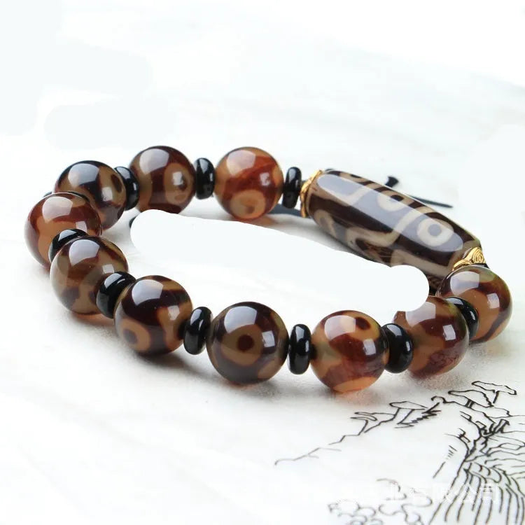 Distressed agate Tibet bead bracelet with three-eye motifs and multiple traditional bead styles on wrist