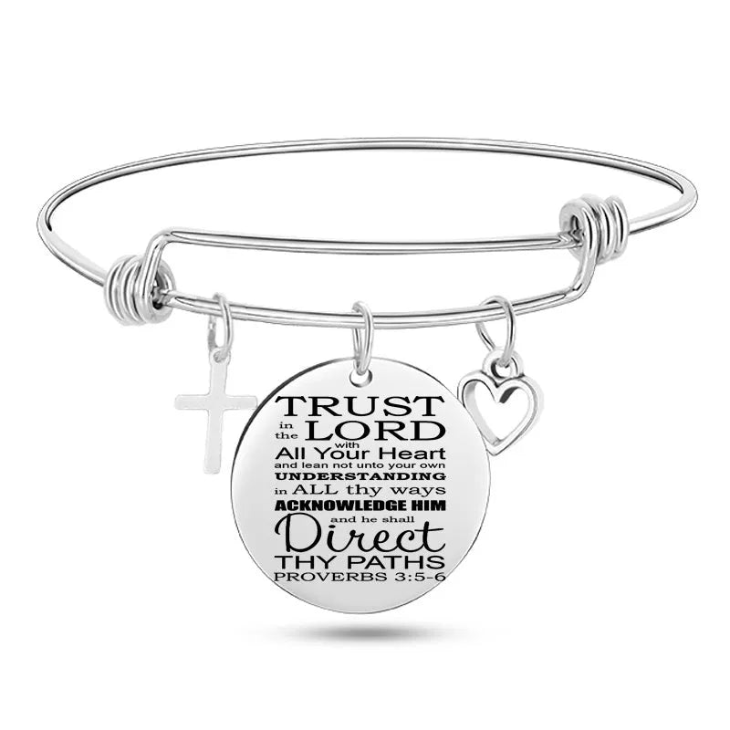 Silver stainless steel bangle bracelet with 25mm cross pendant on a white background