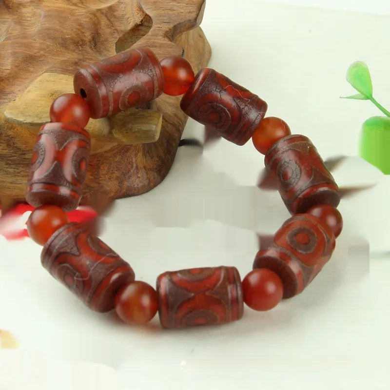 Distressed agate Tibet bead bracelet with three-eye motifs and multiple traditional bead styles on wrist