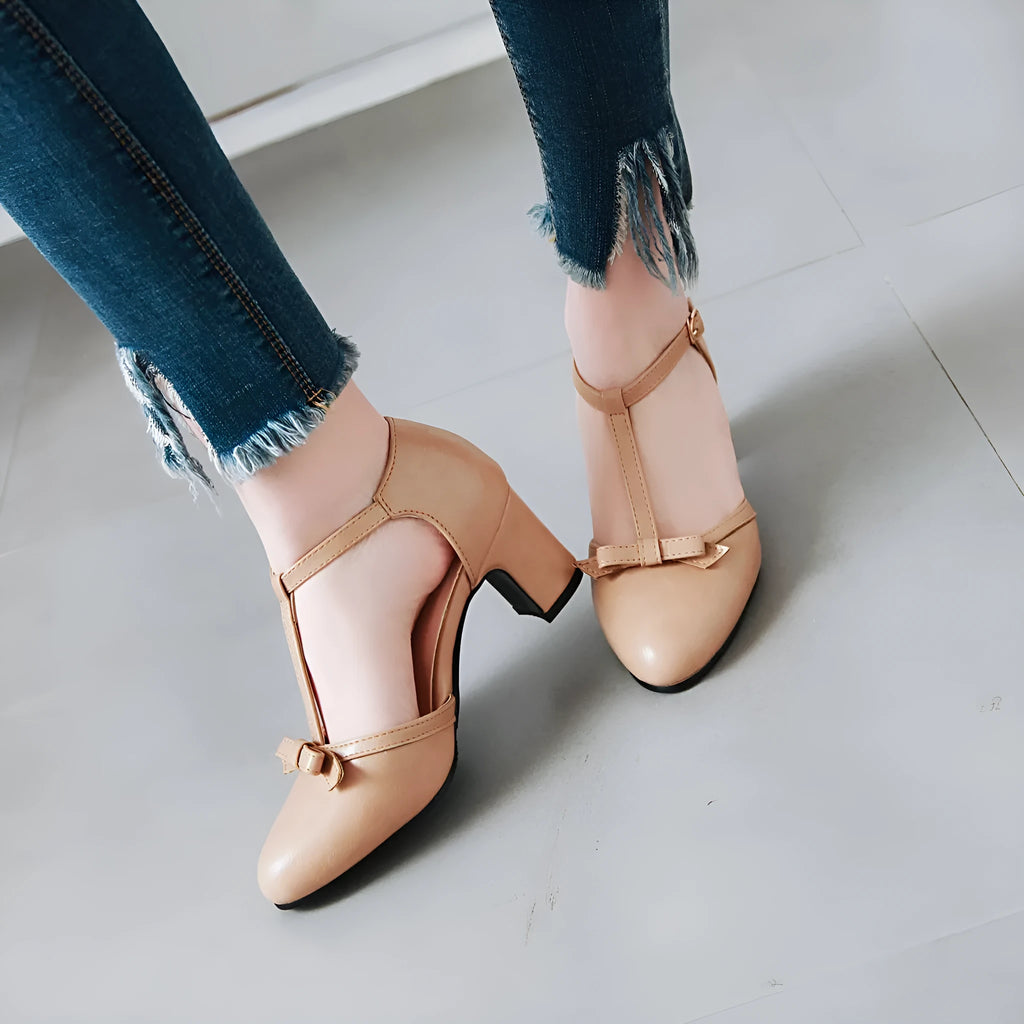 Women's apricot coloured chunky heel sandals with a bow decoration and buckle strap.