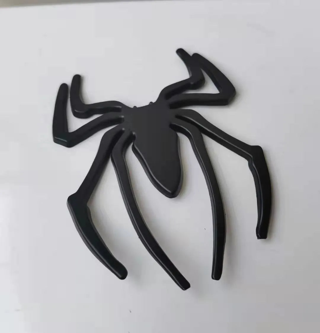 Three-dimensional metal spider car bumper sticker in zinc alloy, shown in gold colour.