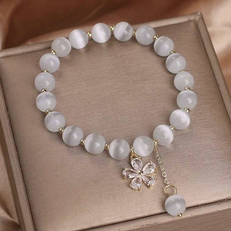 White cat's eye stone women's bracelet with safety buckle pendant and flower tassel detailing