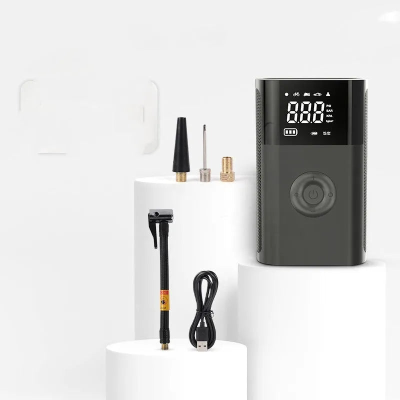 T2191-2 handheld wireless digital display air pump with LED light and multiple nozzle attachments on a table.
