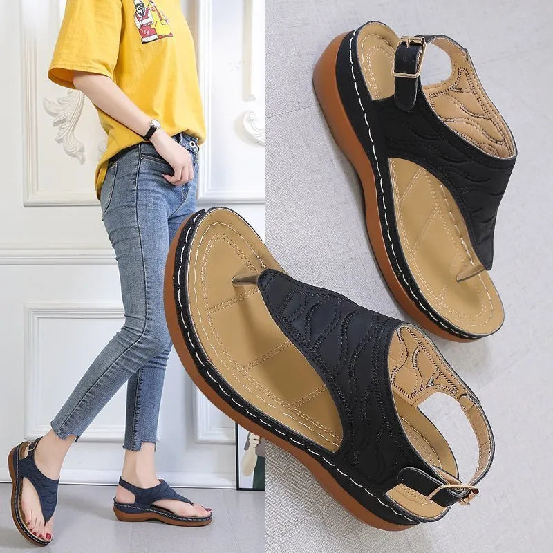 Women's wedge heel flip flop sandals with an adjustable back buckle strap in black.