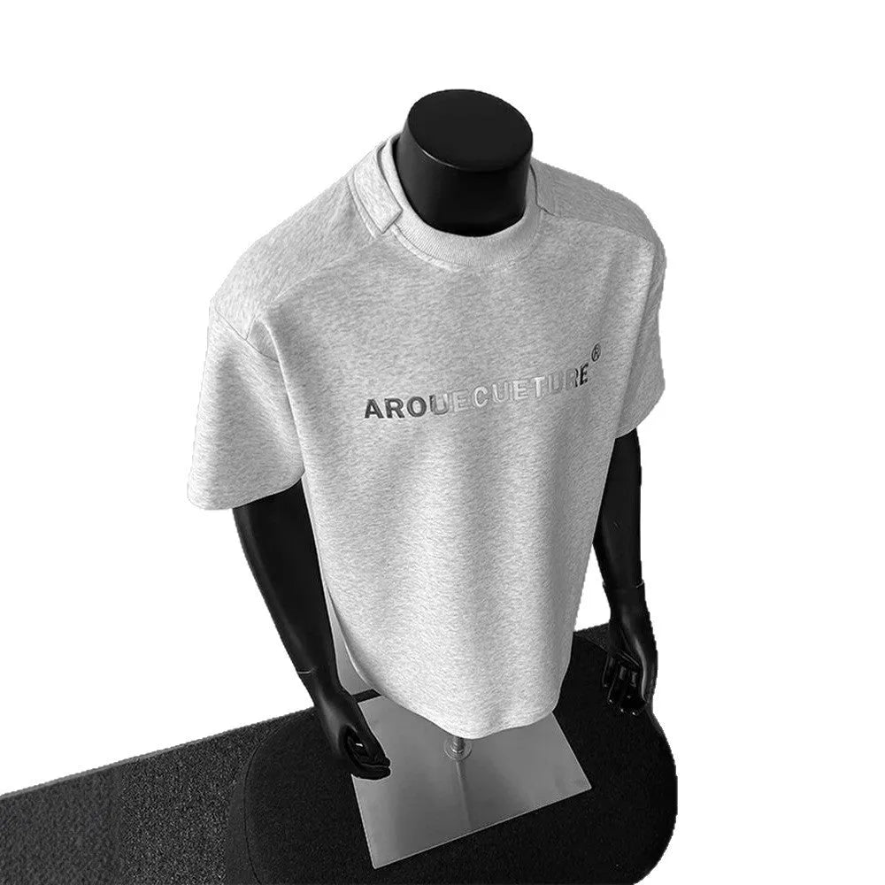 Man wearing a loose fit black short sleeve cotton T-shirt with a white graphic letter print.