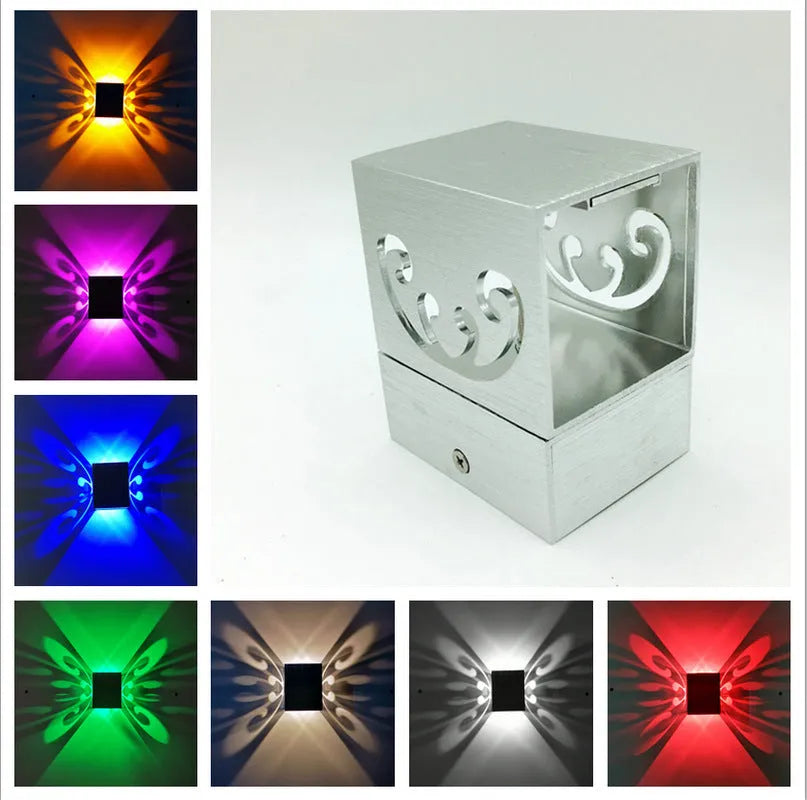 Modern silver aluminium butterfly-shaped LED wall lamp with remote control for changing light colours.