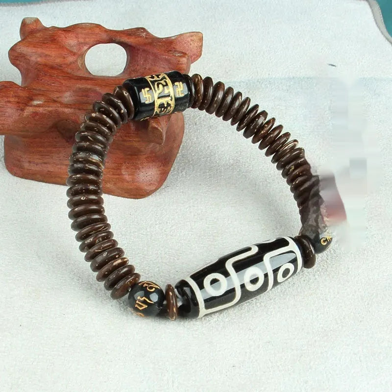 Distressed agate Tibet bead bracelet with three-eye motifs and multiple traditional bead styles on wrist
