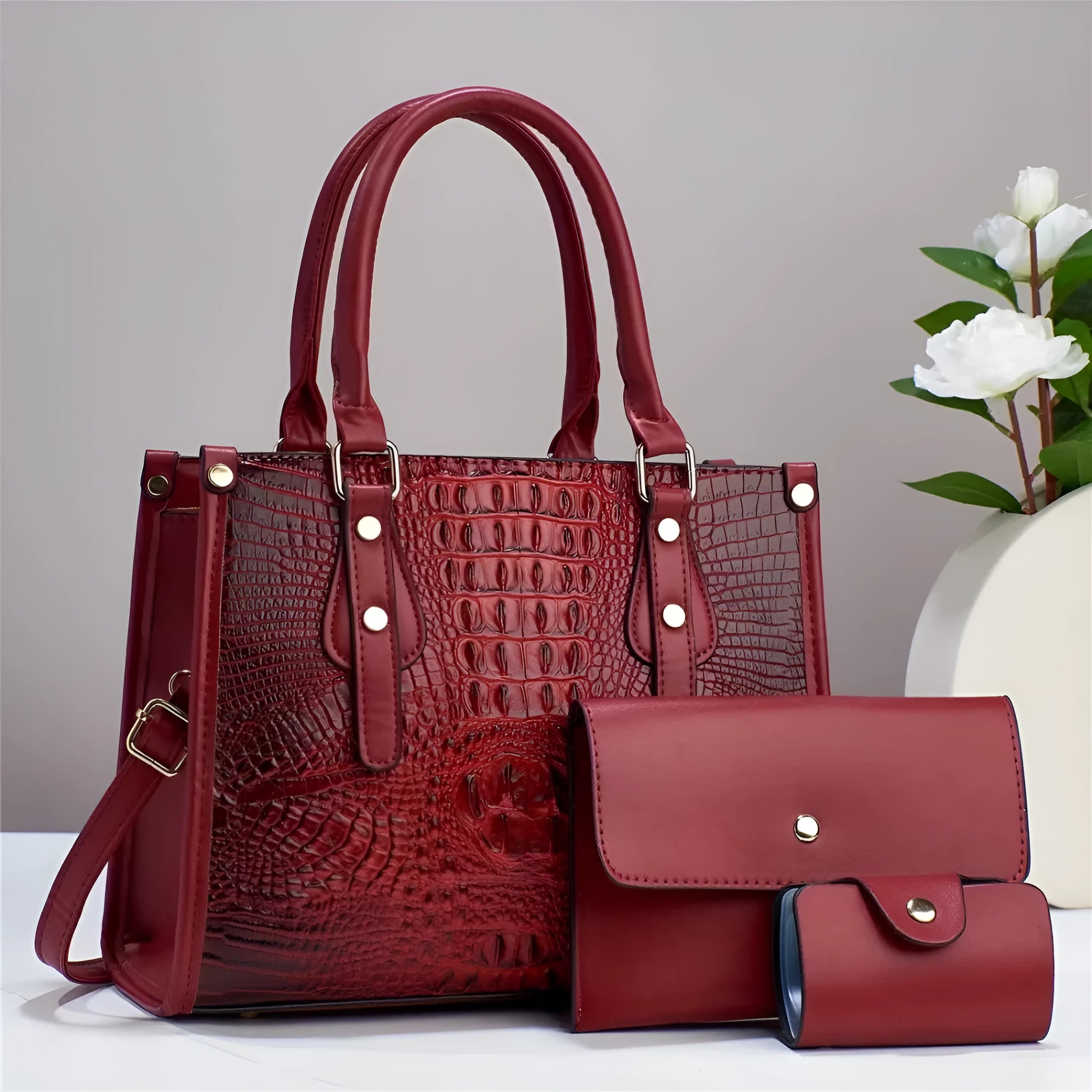 Women's burgundy PU leather bucket crossbody bag with matching wallet and card holder.