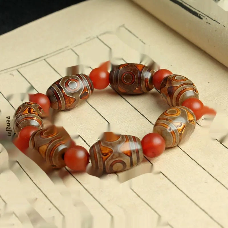Distressed agate Tibet bead bracelet with three-eye motifs and multiple traditional bead styles on wrist