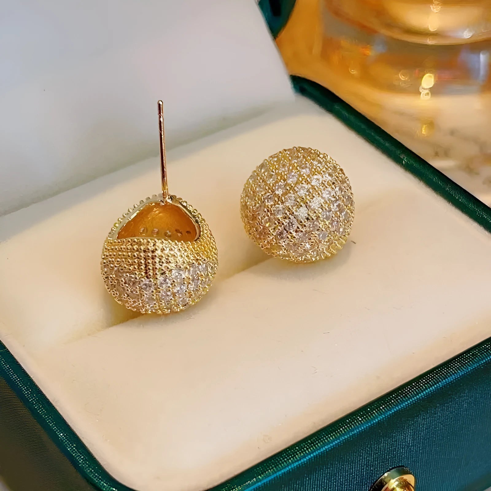 Geometric drop-shaped diamond ear clip earrings in gold and white colours with spherical elements