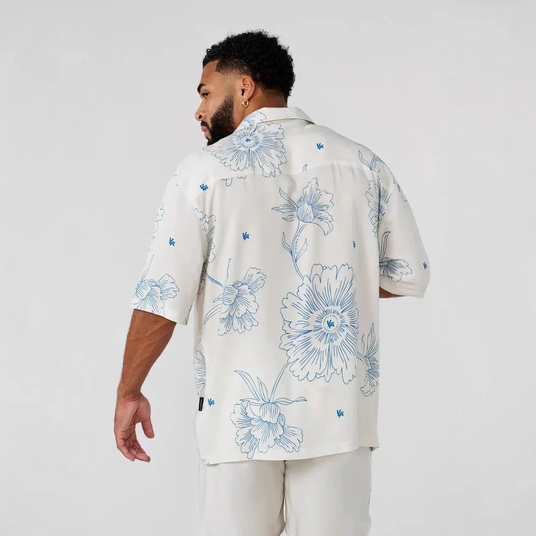 A man's loose grey short-sleeved cardigan with a floral print, showing the elastic band fabric.