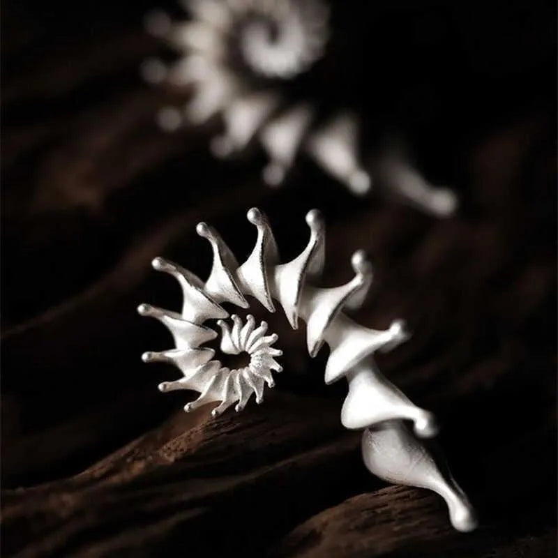 A pair of three-dimensional matte finish conch shell stud earrings in alloy with irregular shaping.