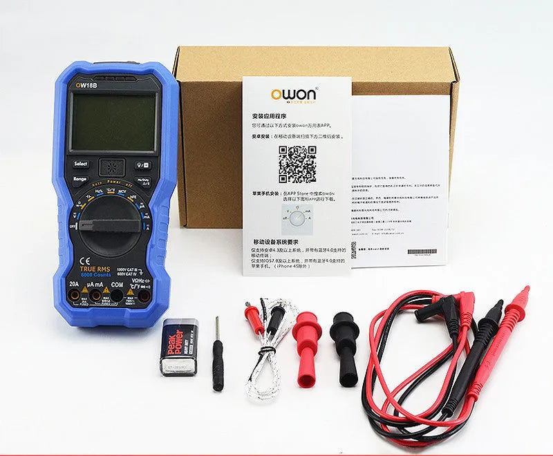 Handheld digital multimeter on a workbench with test probes.