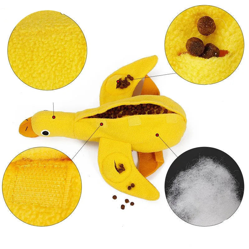 Yellow plush dog toy with attached rubber duck and a treat slot on a white background.