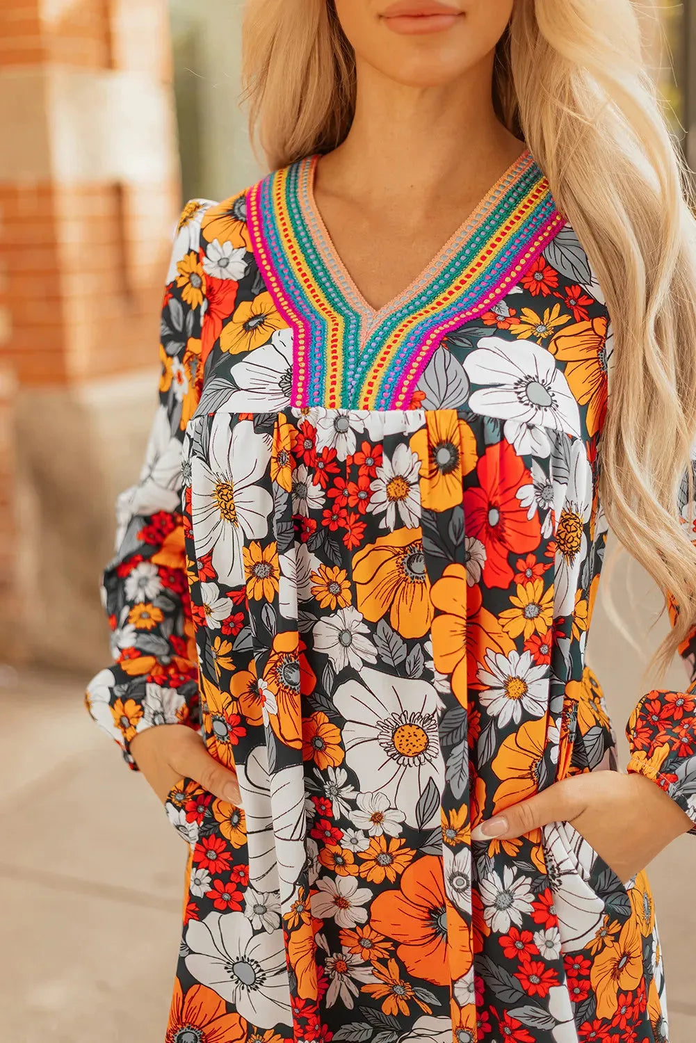 Orange floral print women's mini dress with striped lace detailing, V-neck, and long sleeves.