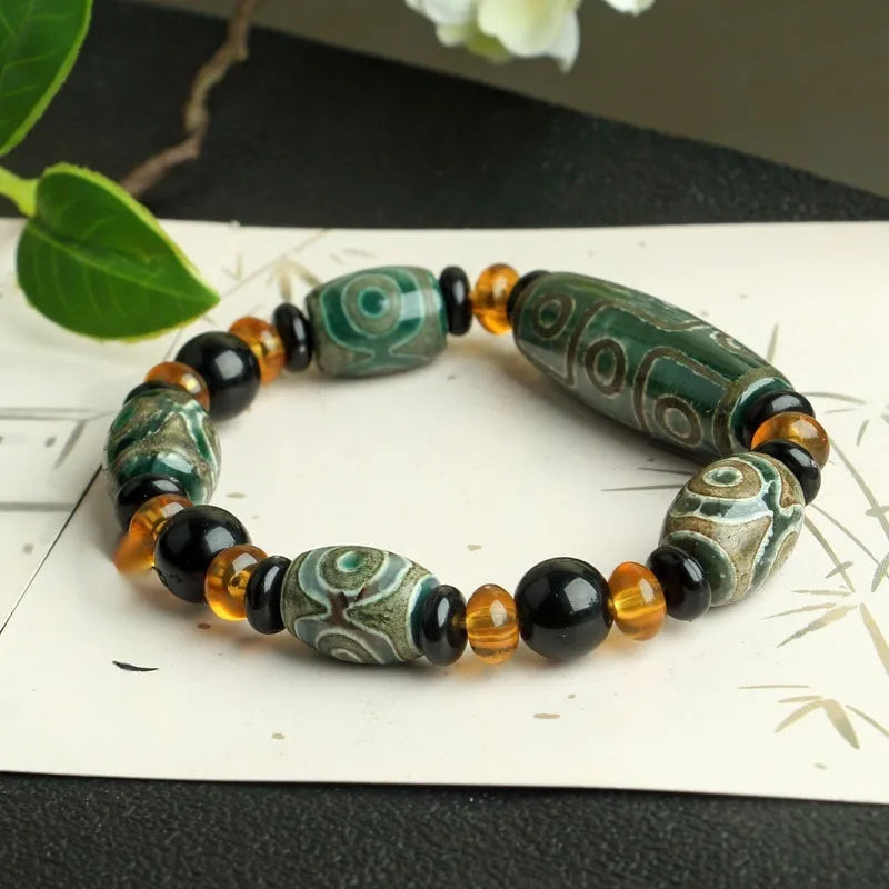 Distressed agate Tibet bead bracelet with three-eye motifs and multiple traditional bead styles on wrist