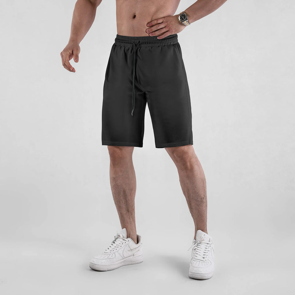 Man wearing loose-fitting black quick-dry mesh shorts with an elasticated waist.