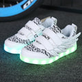 Children's plum red and white LED light-up sneakers with USB charging port visible