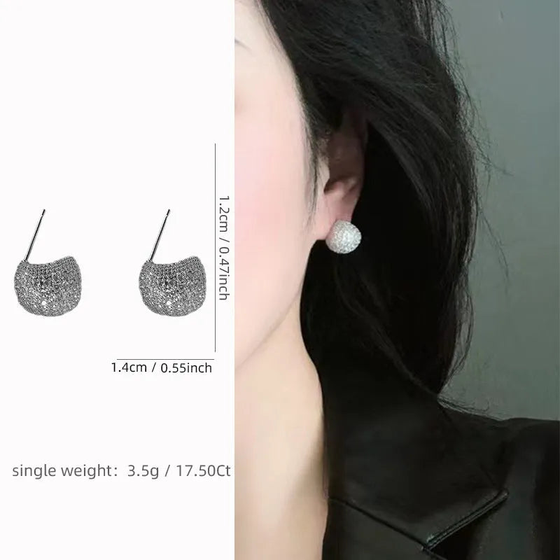 Geometric drop-shaped diamond ear clip earrings in gold and white colours with spherical elements